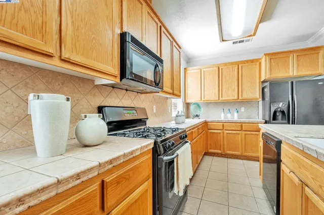 a kitchen with granite countertop a stove a sink and a microwave