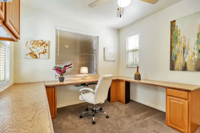 a view of a workspace with furniture and a window