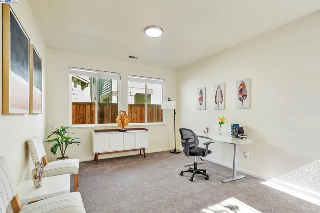 a view of a workspace with furniture and a window