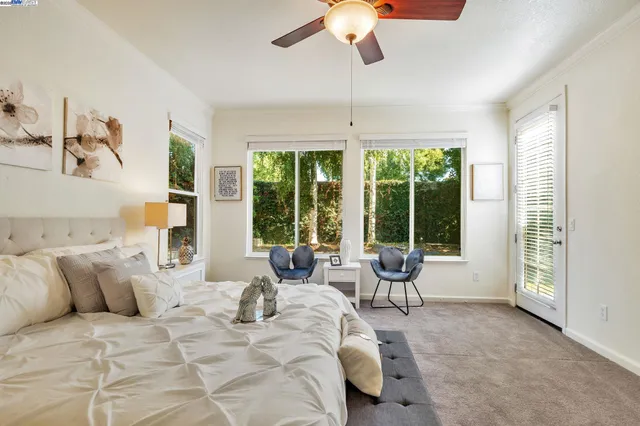 a bedroom with a large bed and windows