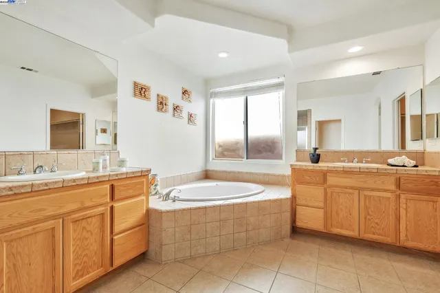 a spacious bathroom with a granite countertop sink mirror and bathtub