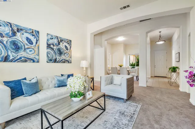 a living room with furniture and a painting on the wall