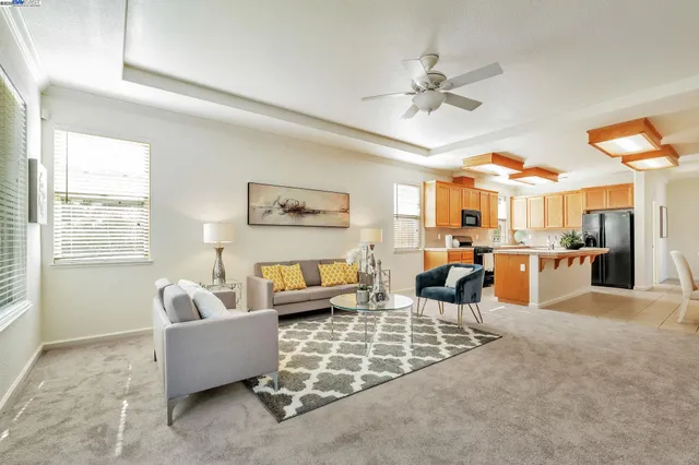 a living room with furniture kitchen view and a large window