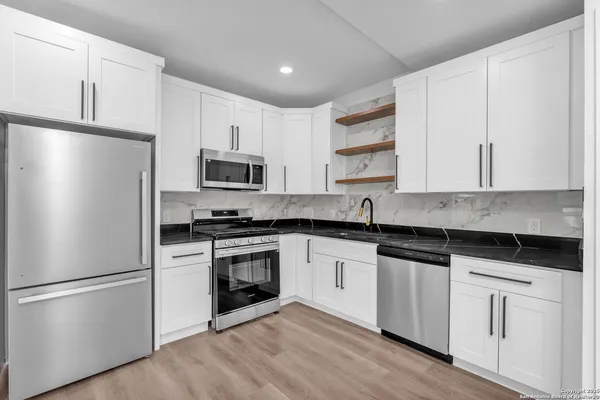 a kitchen with a sink a microwave and cabinets