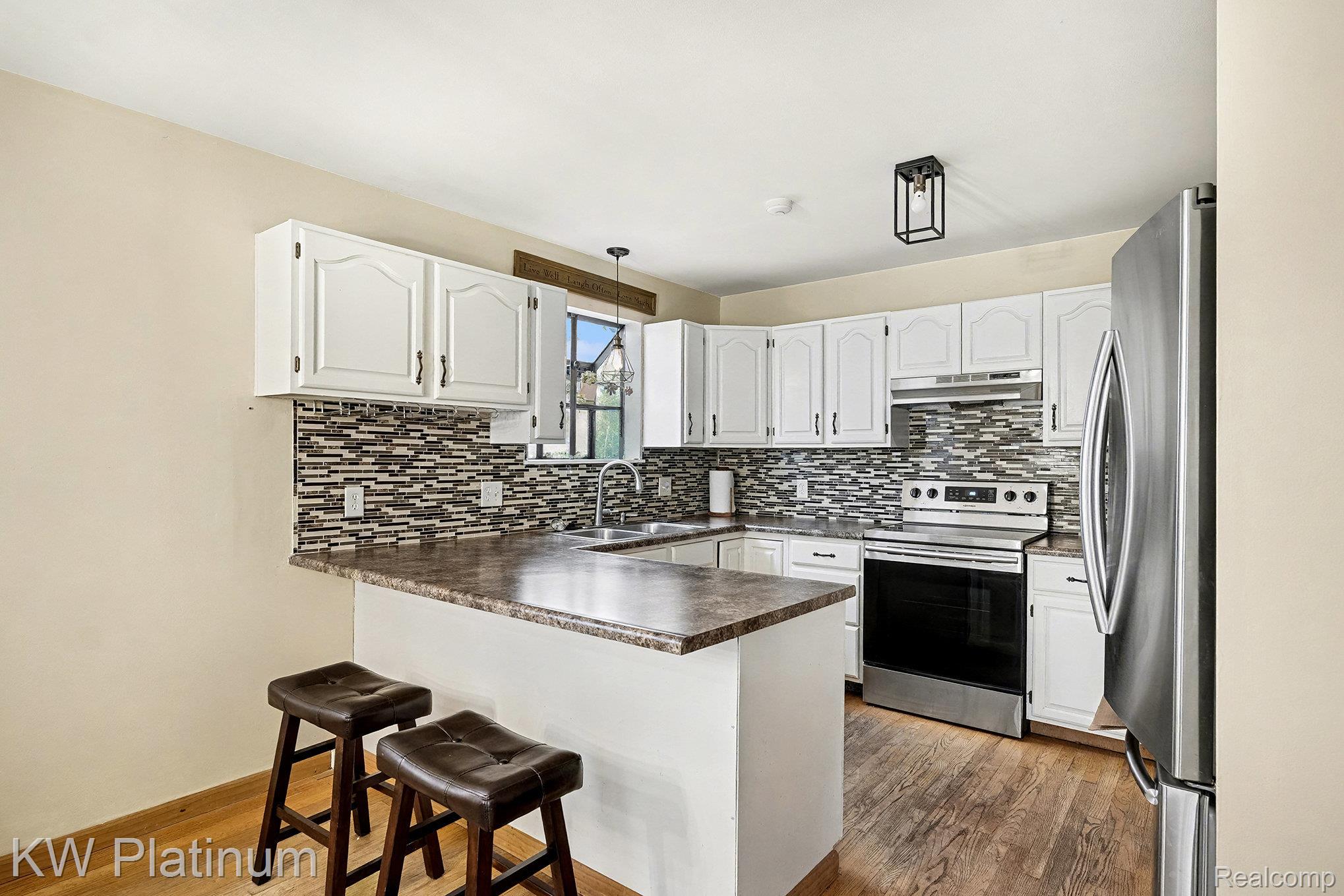 185 Michelson Road Rochester, MI 48307 - Photo 17 of 36 Kitchen featuring stainless steel appliances, white cabinets, a peninsula, and dark countertops