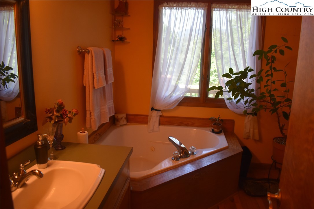 592 River Hills Road Lansing, NC 28643 - Photo 21 of 36 a bathroom with a tub sink and mirror