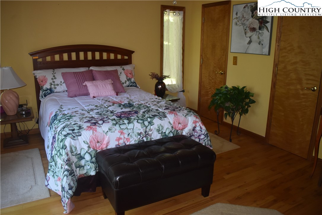 592 River Hills Road Lansing, NC 28643 - Photo 25 of 36 a bedroom with a bed and a potted plant