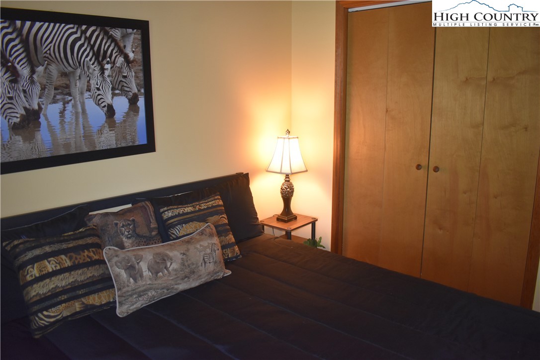 592 River Hills Road Lansing, NC 28643 - Photo 33 of 36 a room with a bed and painting on the wall