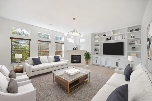a living room with furniture a flat screen tv and a fireplace