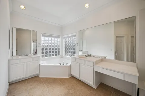 a bathroom with a tub sink and mirror
