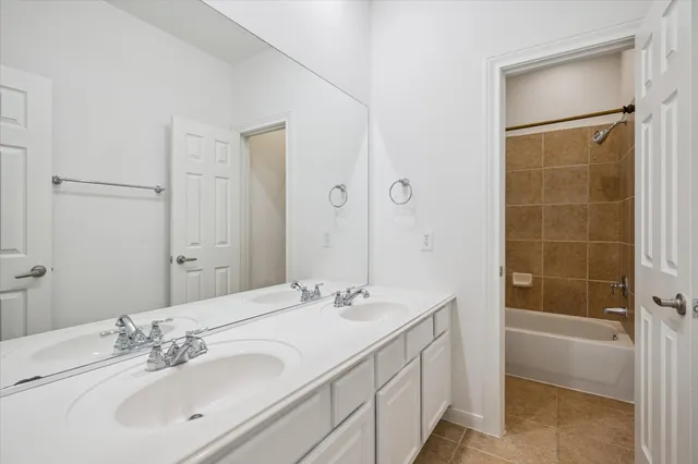 a bathroom with a double vanity sink mirror and shower