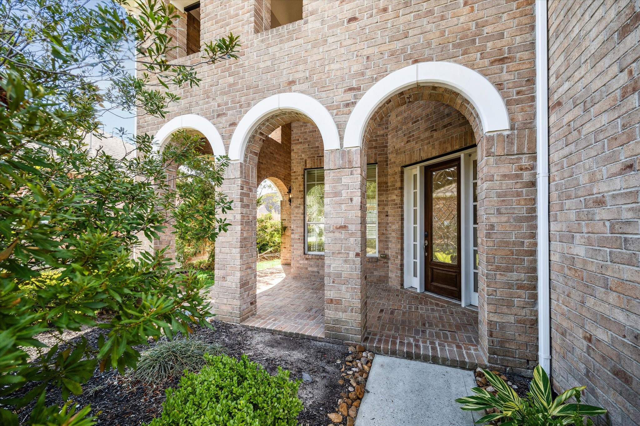 7211 Diamond Falls Lane Spring, TX 77389 - Photo 27 of 29 Inviting front porch with elegant brick archways and classic architectural detail.