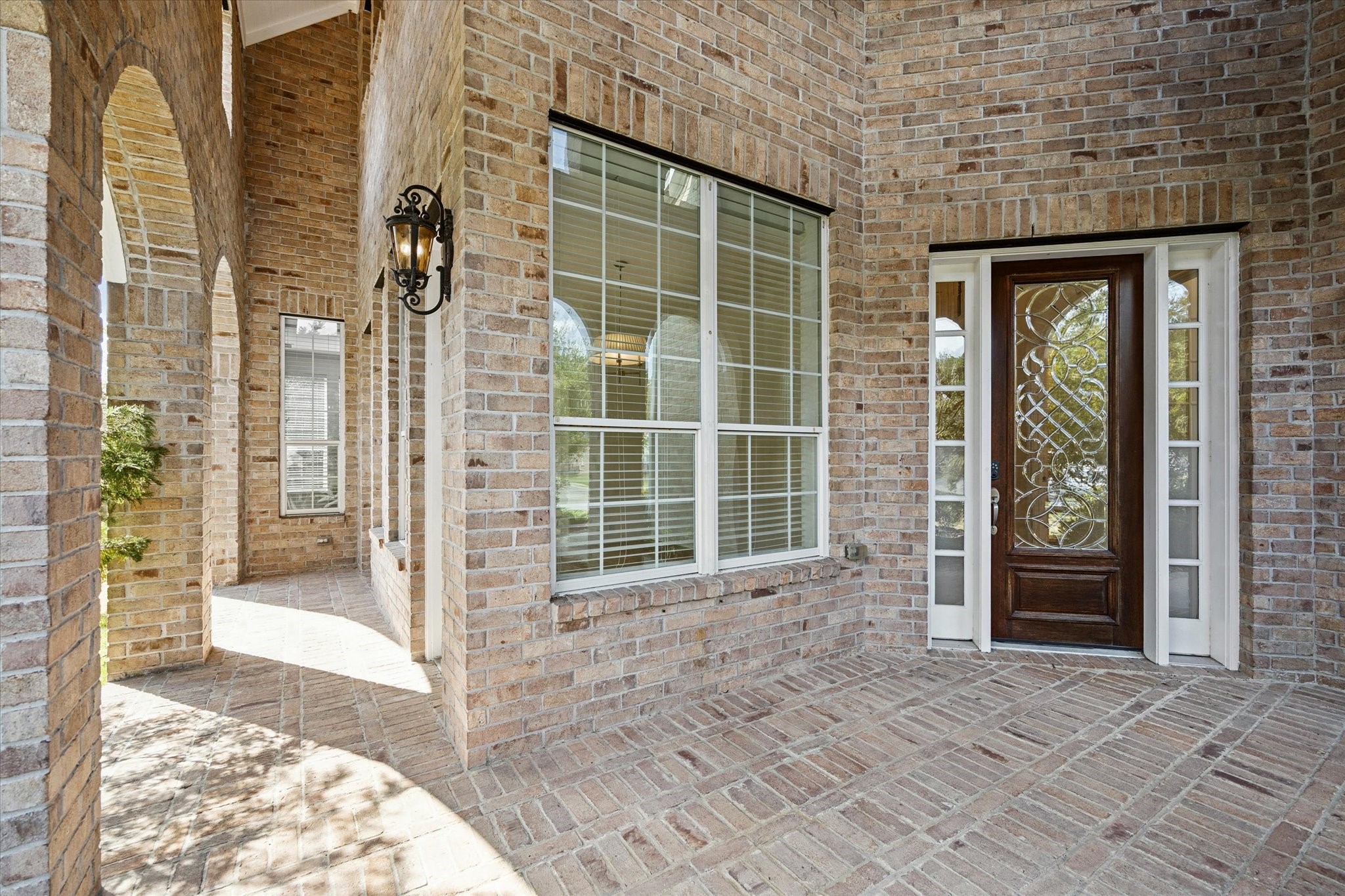7211 Diamond Falls Lane Spring, TX 77389 - Photo 28 of 29 Covered brick porch with arched openings and decorative lighting.