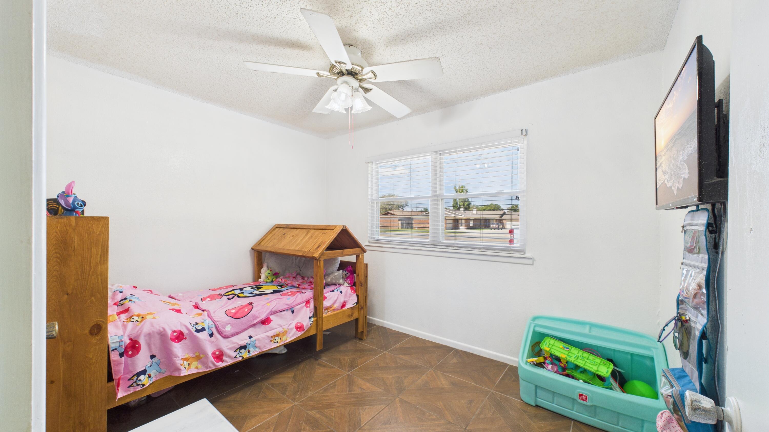 5431 34th Street Lubbock, TX 79407 - Photo 12 of 22 a bedroom with a bed and a chandelier