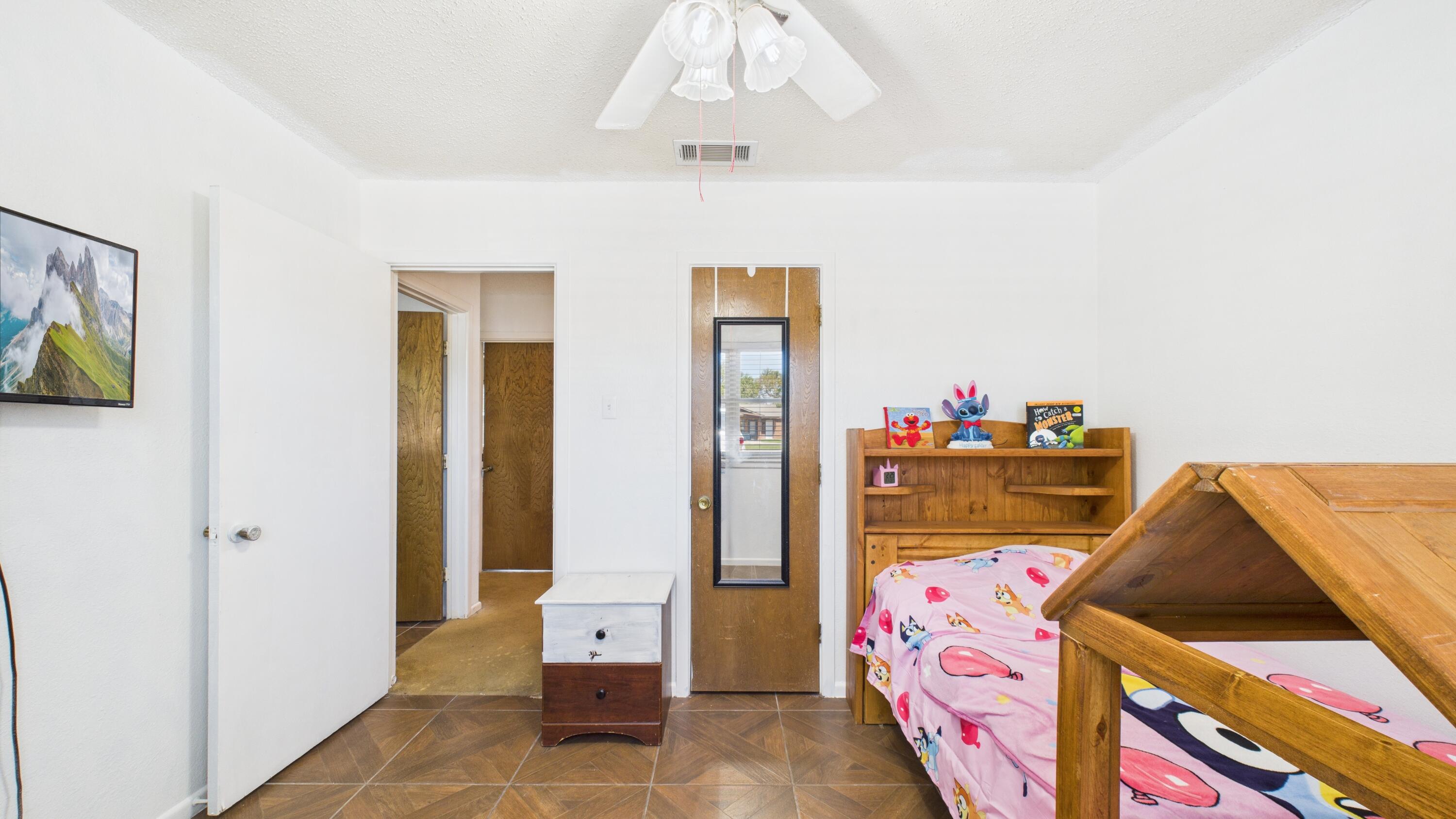 5431 34th Street Lubbock, TX 79407 - Photo 13 of 22 a bedroom with a bed and a chandelier