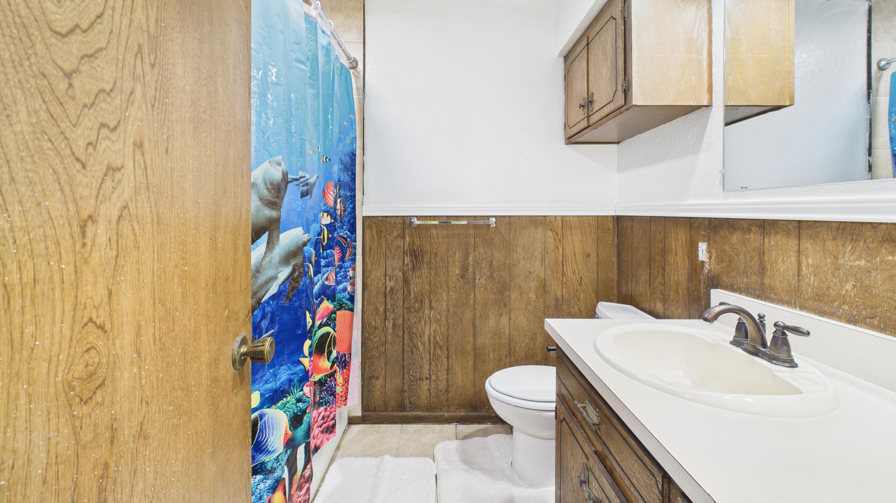 5431 34th Street Lubbock, TX 79407 - Photo 14 of 22 a bathroom with a sink a toilet and shower curtain
