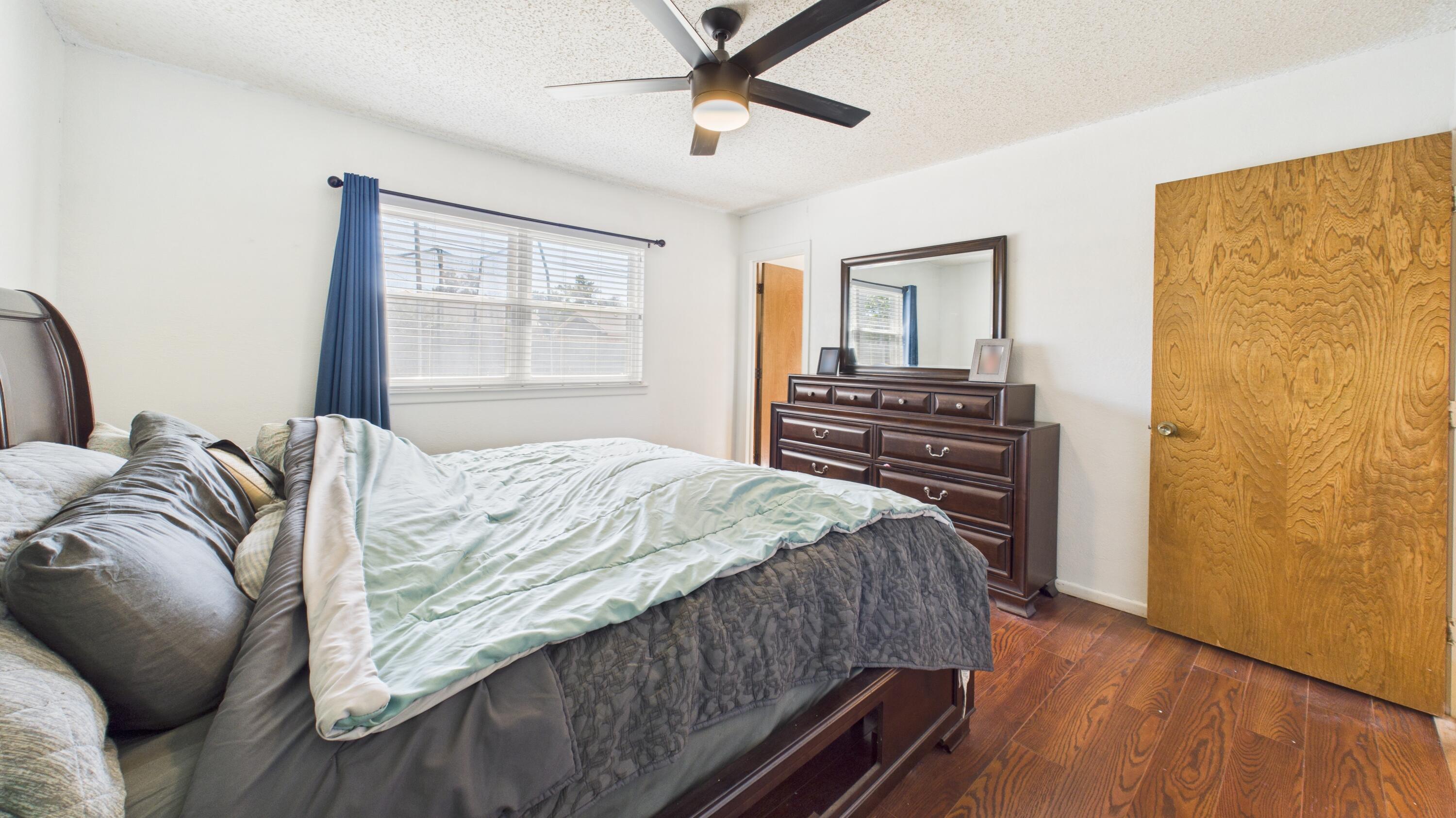 5431 34th Street Lubbock, TX 79407 - Photo 17 of 22 a bedroom with a bed and wooden floor