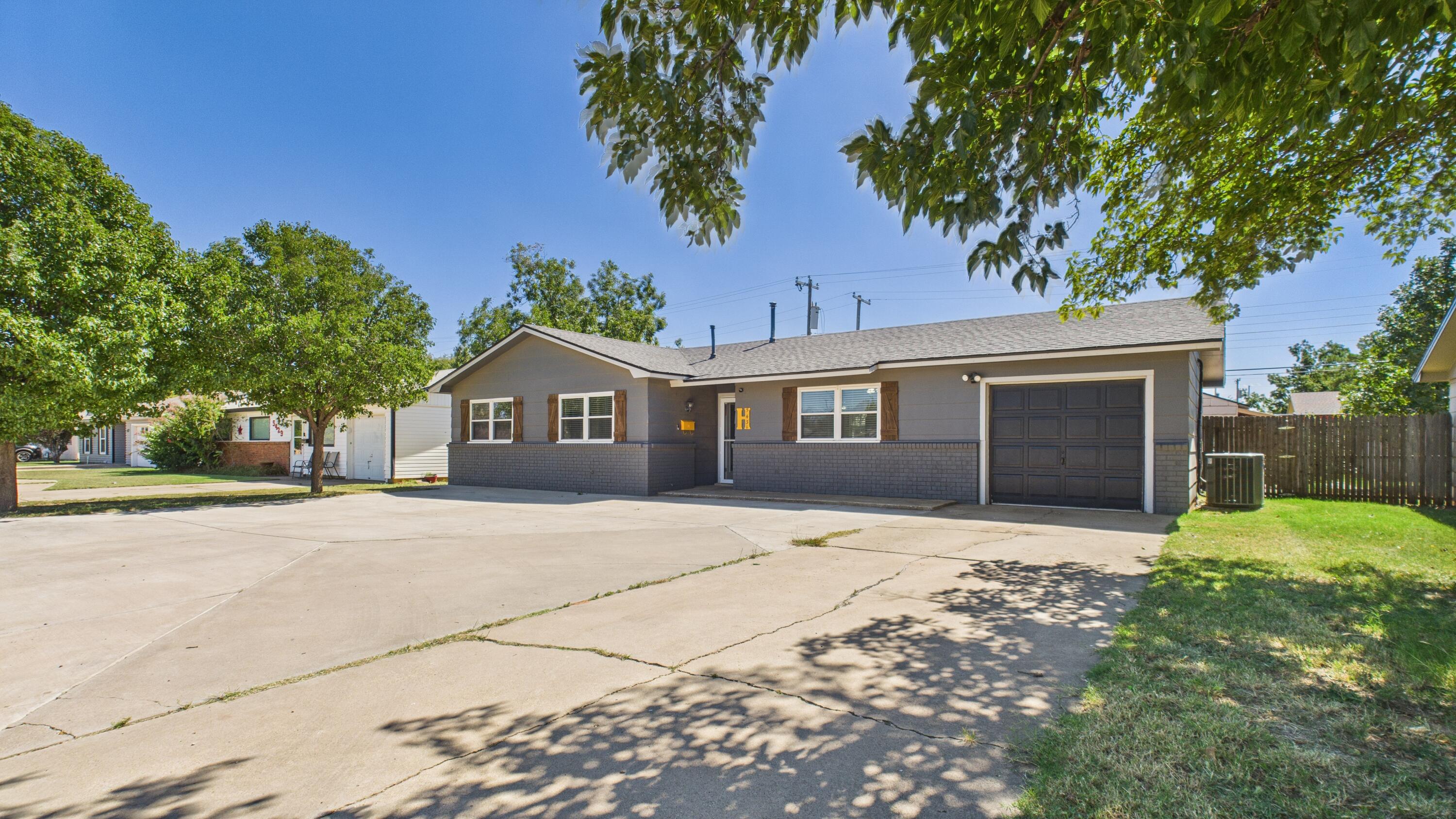 5431 34th Street Lubbock, TX 79407 - Photo 2 of 22 a front view of a house with a yard and garage