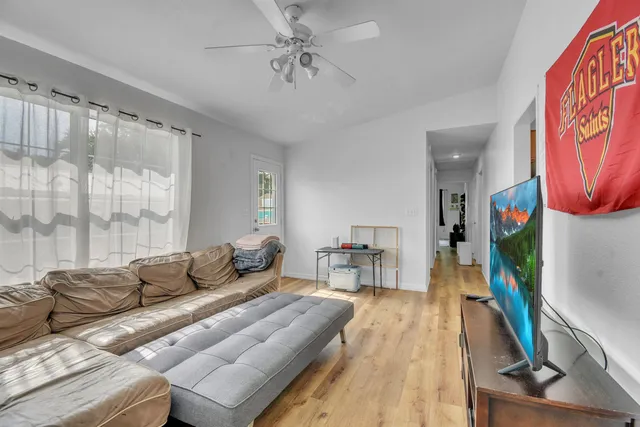 a living room with furniture a flat screen tv and a floor to ceiling window