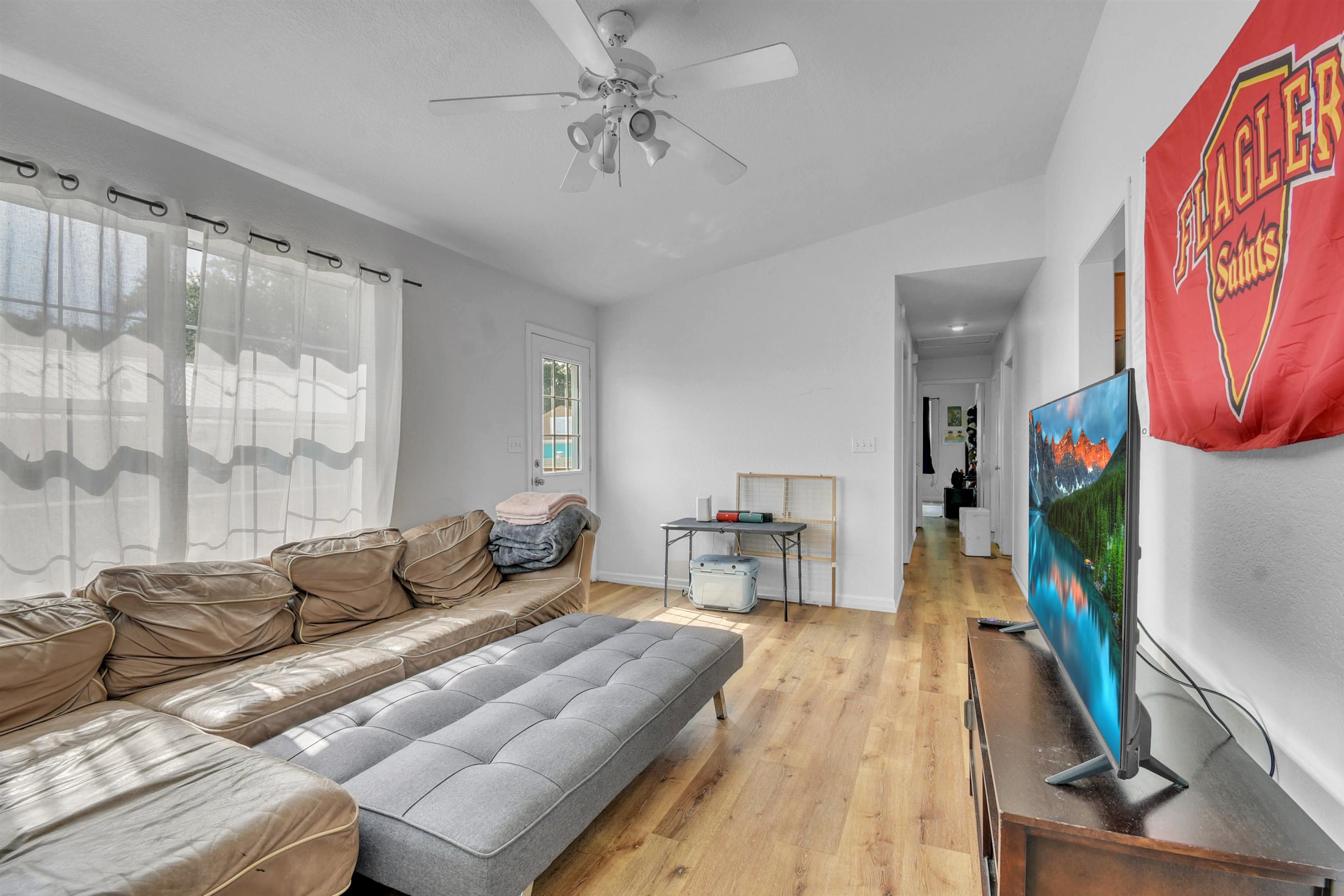 67 Anderson Street St. Augustine, FL 32084 - Photo 11 of 22 a living room with furniture a flat screen tv and a floor to ceiling window