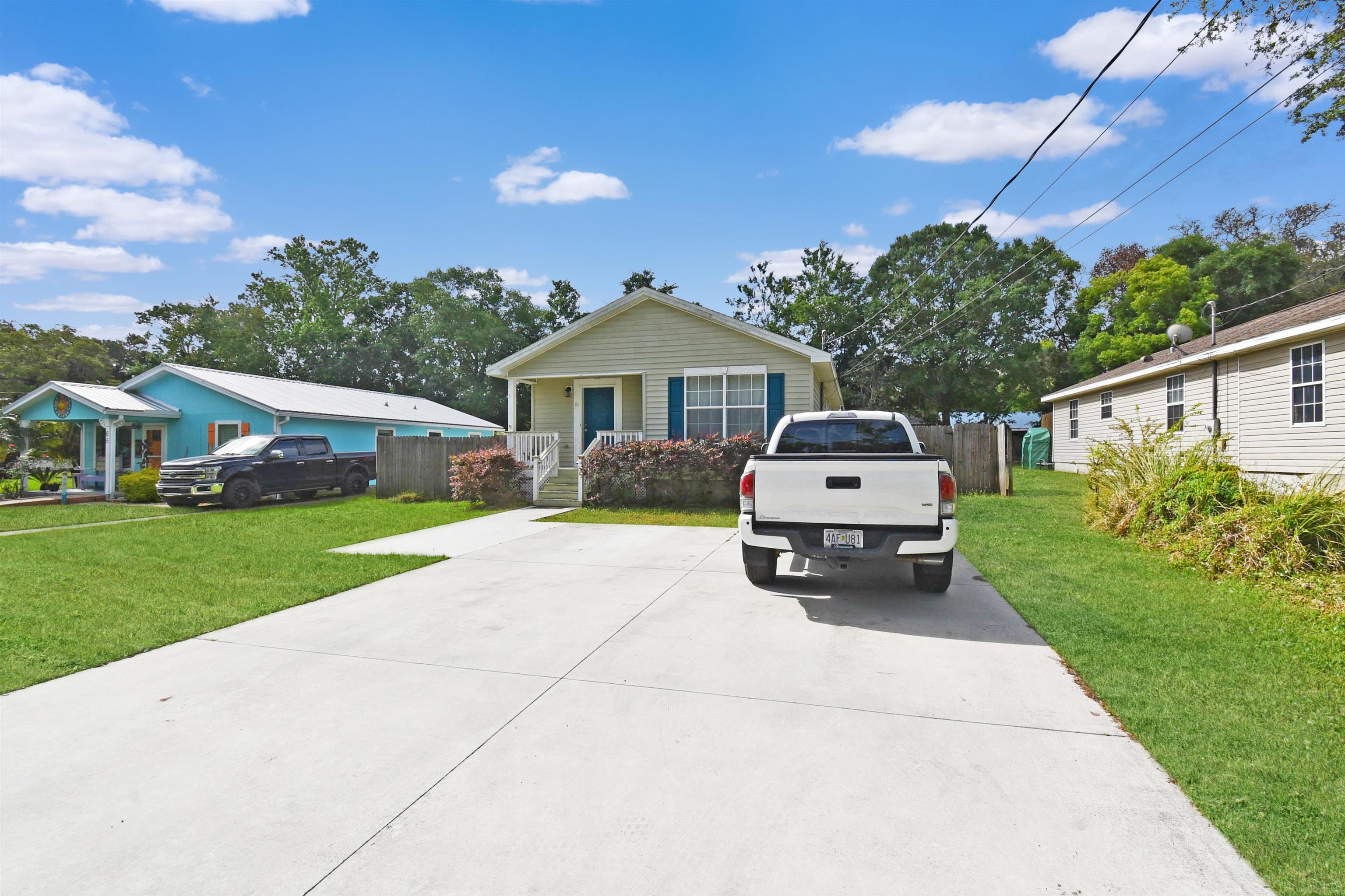 67 Anderson Street St. Augustine, FL 32084 - Photo 4 of 22 a car parked in front of a house next to a yard