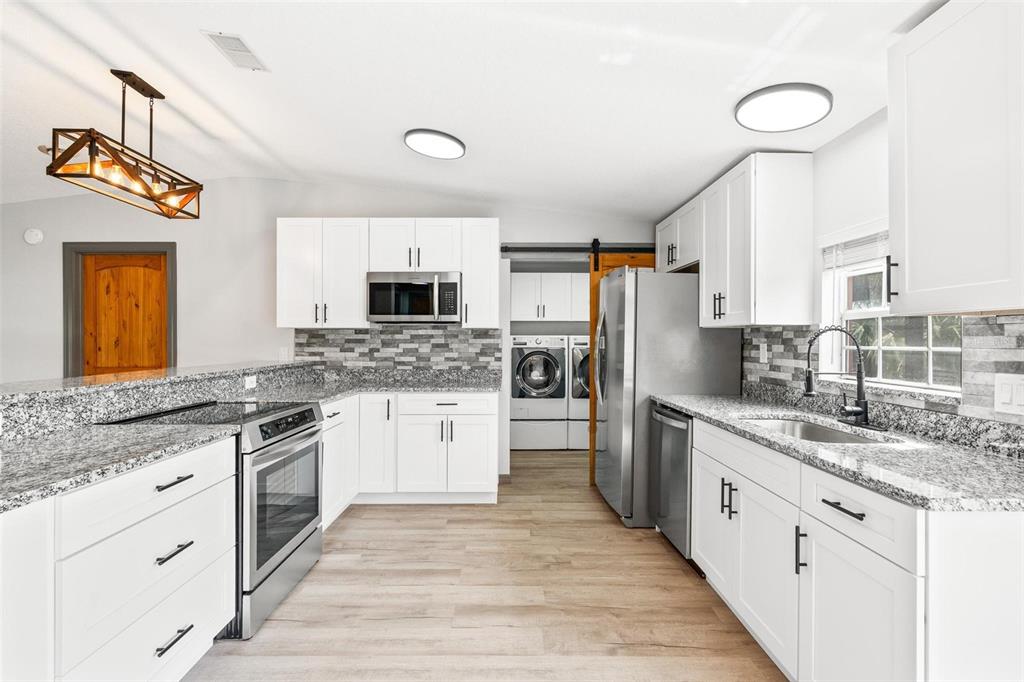 41534 Thomas Boat Landing Road Umatilla, FL 32784 - Photo 5 of 48 a kitchen with granite countertop a sink stainless steel appliances and white cabinets