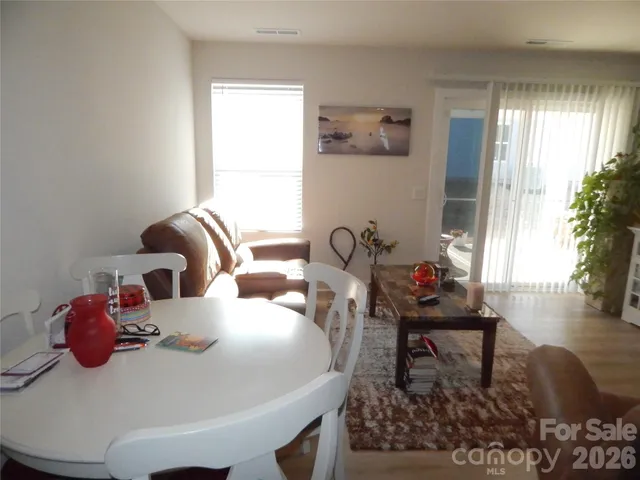 a living room with furniture a flat screen tv and a refrigerator