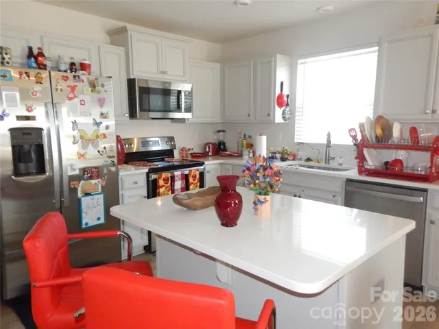 a view of a kitchen with kitchen island and a sink