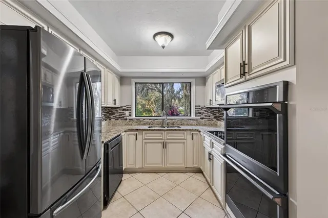 a kitchen with stainless steel appliances granite countertop a refrigerator sink and stove
