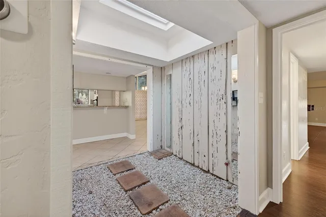 a view of a hallway with wooden floor and a living room