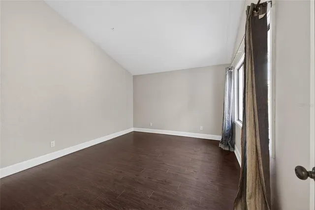 an empty room with wooden floor and entrance
