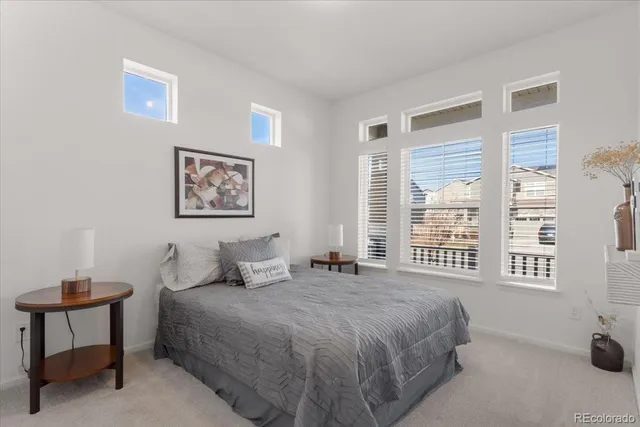 a bedroom with a bed a wall painting and a window