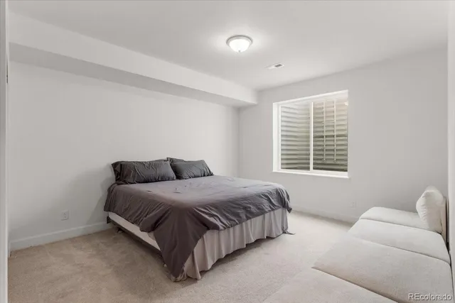 a spacious bedroom with a bed and a couch