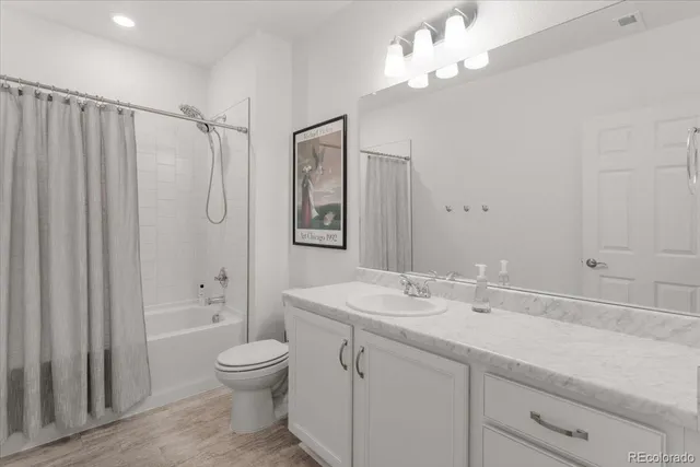 a bathroom with a granite countertop sink a toilet and shower