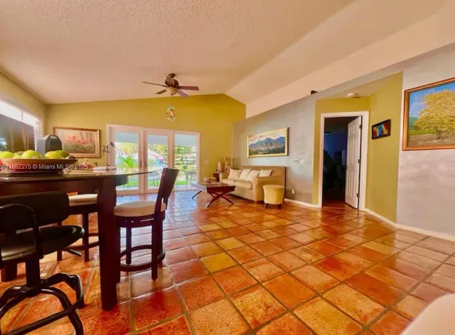 a living room with furniture a dining table and a large window