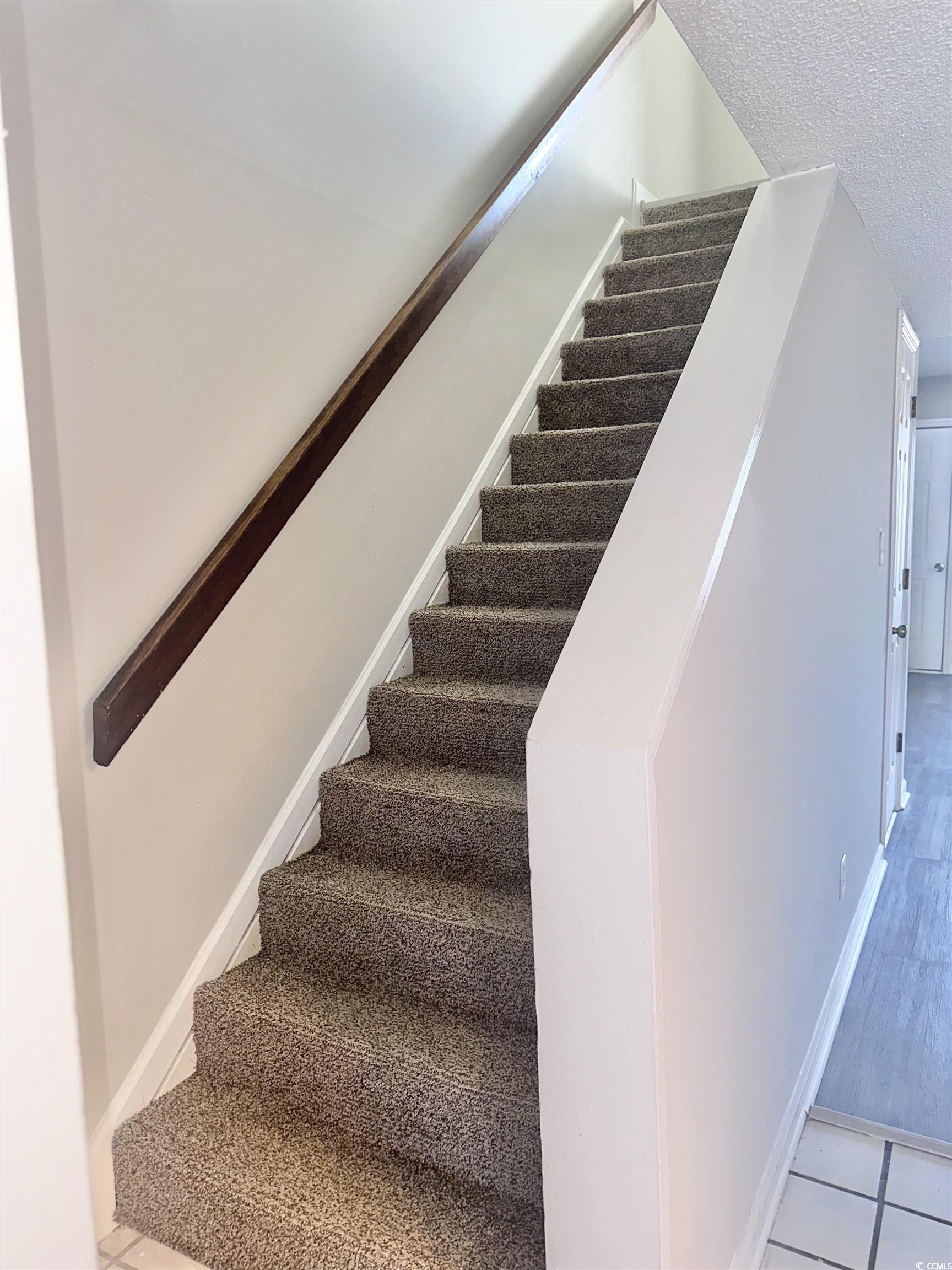 401 Garden Drive, Unit 100B Myrtle Beach, SC 29575 - Photo 12 of 23 Staircase with a textured ceiling and tile patterned floors