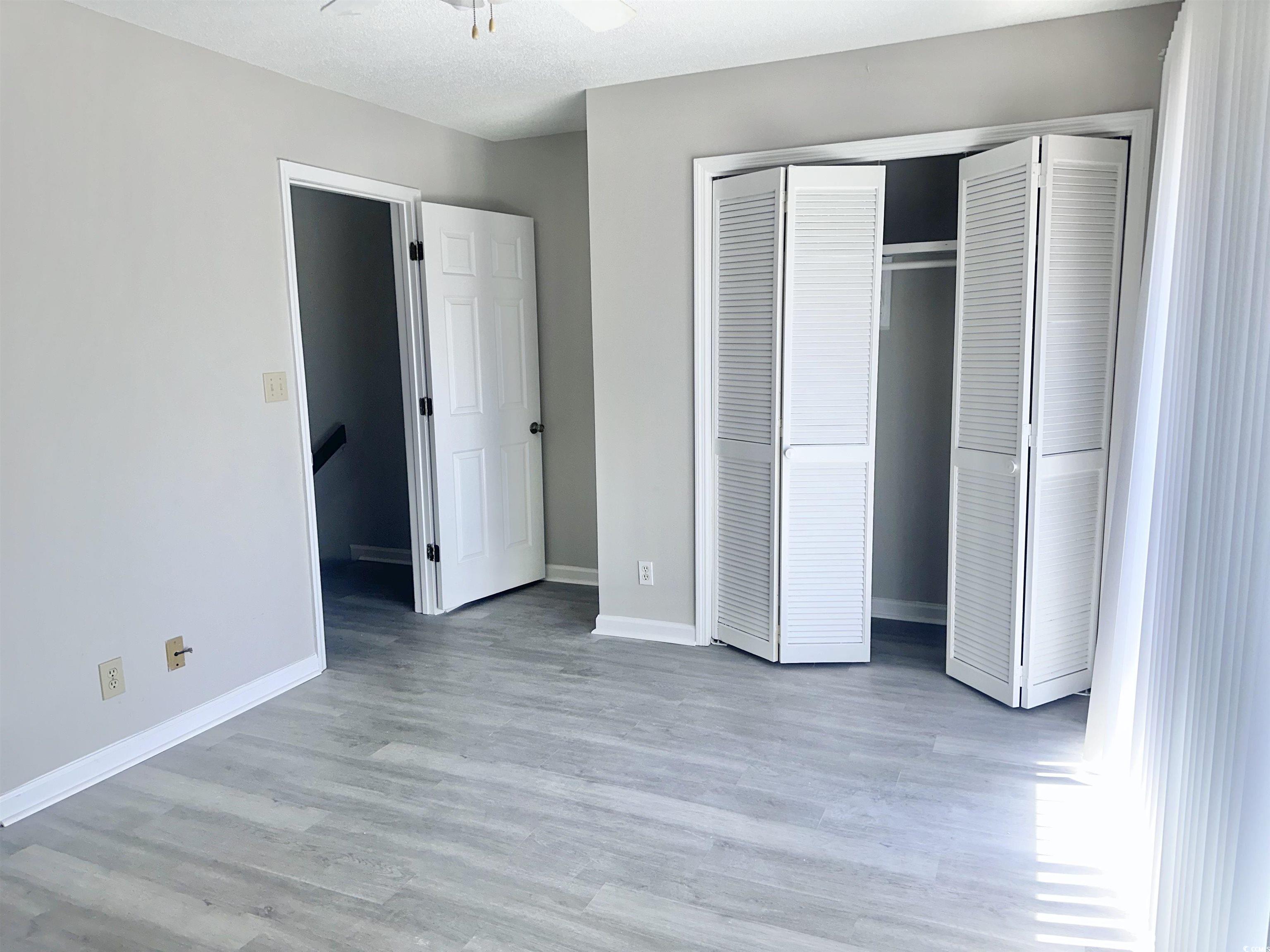 401 Garden Drive, Unit 100B Myrtle Beach, SC 29575 - Photo 14 of 23 Unfurnished bedroom with a closet and light wood-style floors