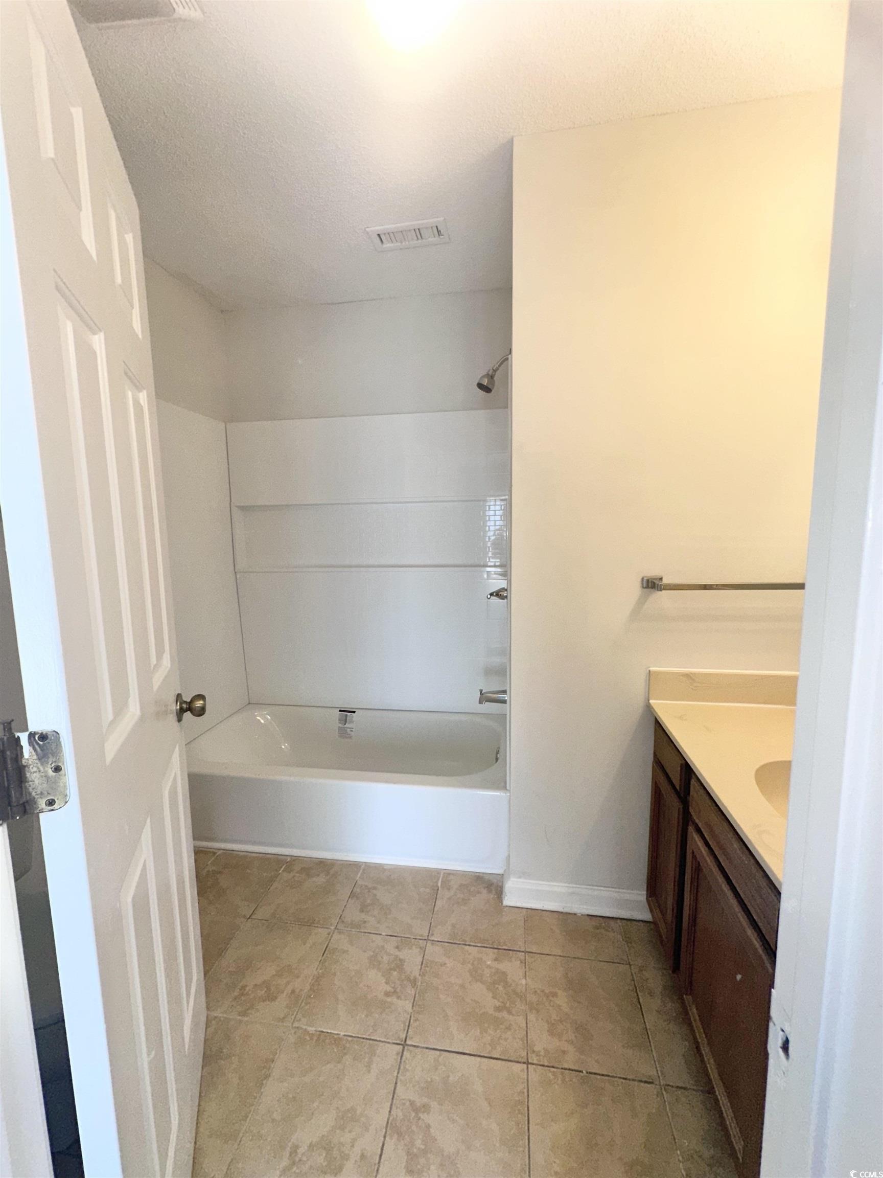401 Garden Drive, Unit 100B Myrtle Beach, SC 29575 - Photo 15 of 23 Full bathroom with vanity, washtub / shower combination, and tile patterned flooring