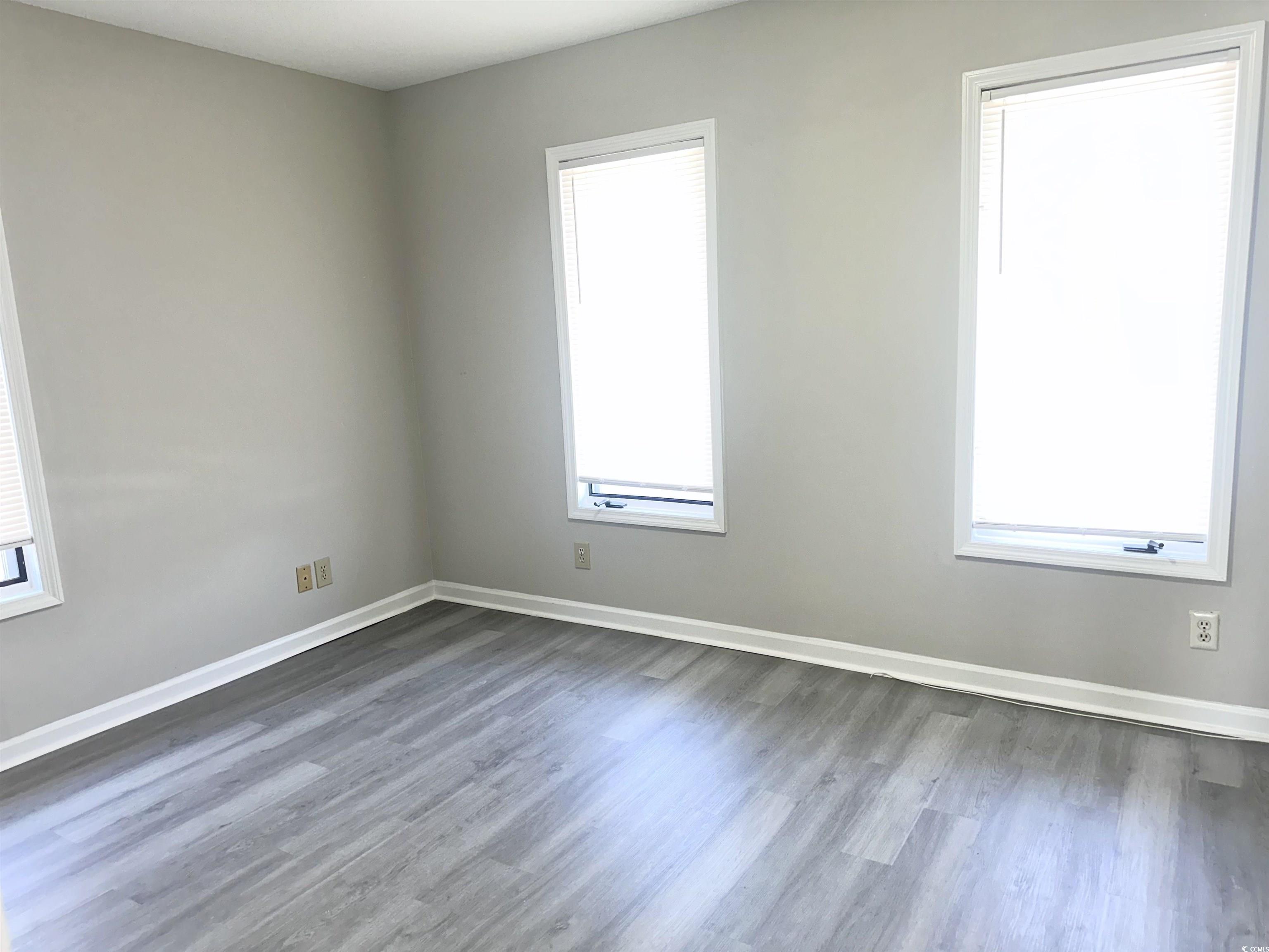 401 Garden Drive, Unit 100B Myrtle Beach, SC 29575 - Photo 18 of 23 Empty room with dark wood finished floors