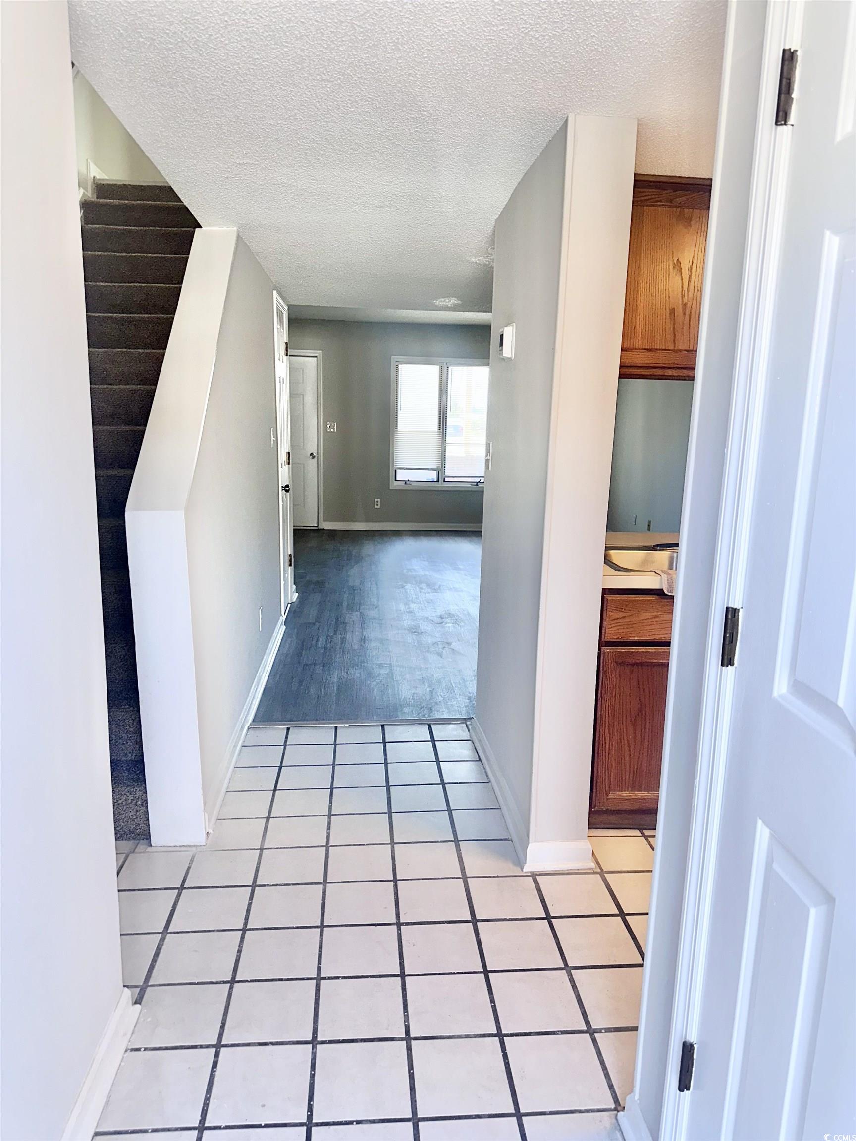 401 Garden Drive, Unit 100B Myrtle Beach, SC 29575 - Photo 2 of 23 Hall with a textured ceiling and light tile patterned floors