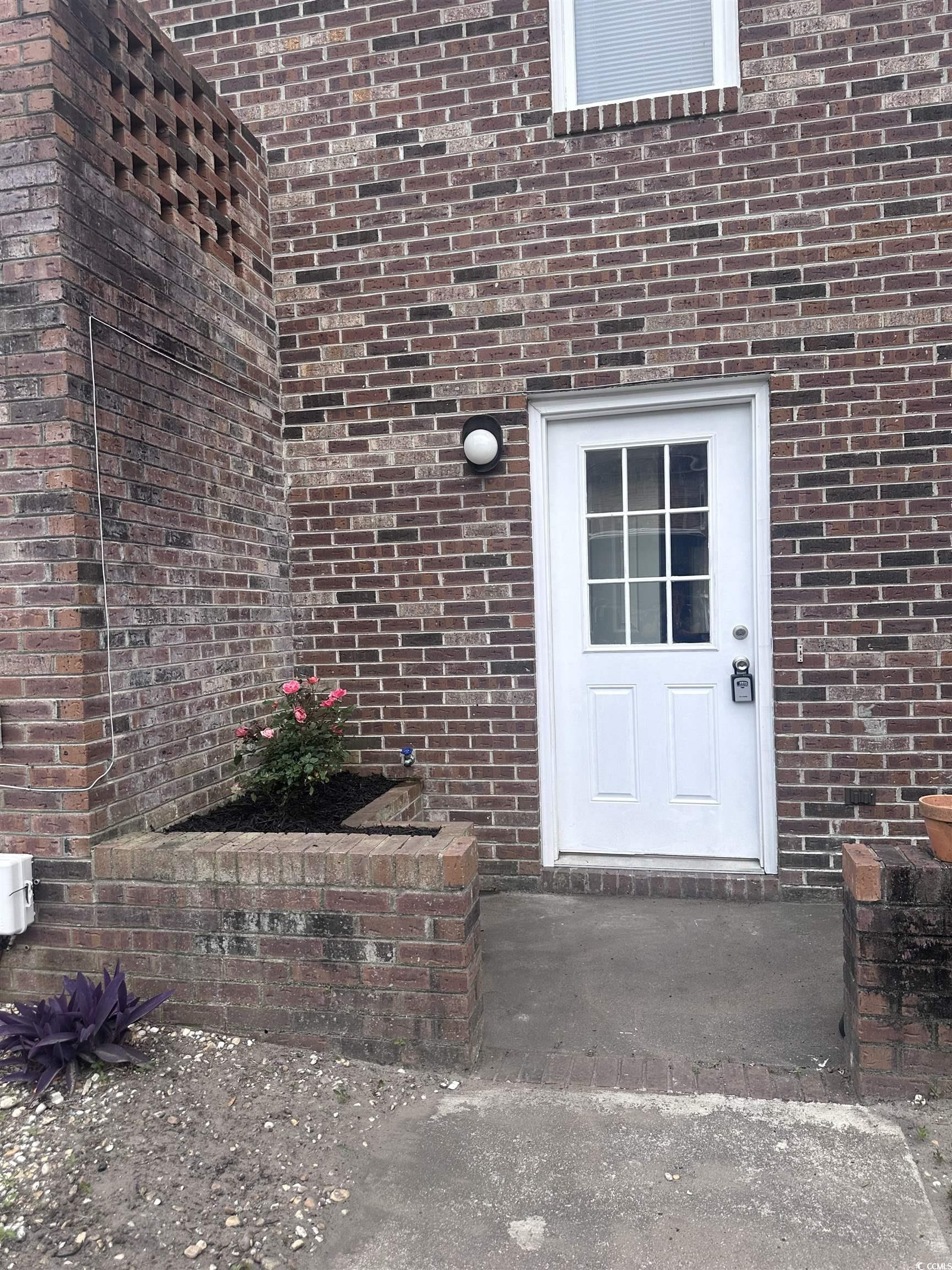 401 Garden Drive, Unit 100B Myrtle Beach, SC 29575 - Photo 22 of 23 Entrance to property featuring brick siding