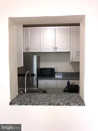 a kitchen with white cabinets and a counter top