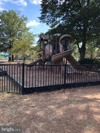 a view of a backyard with wooden fence and trees