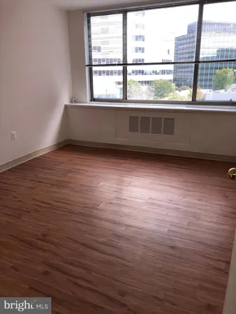 a view of empty room with wooden floor