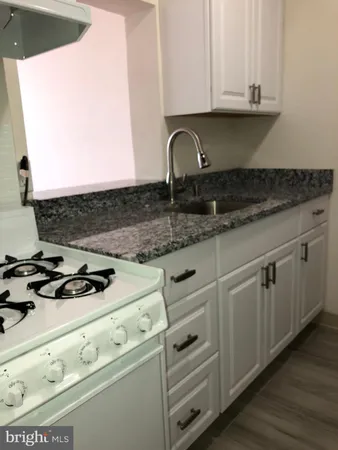 a kitchen with granite countertop a sink and a stove