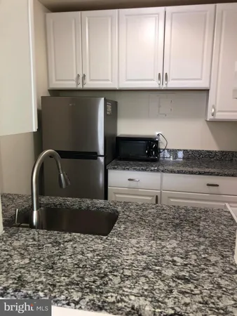 a kitchen with granite countertop cabinets and window