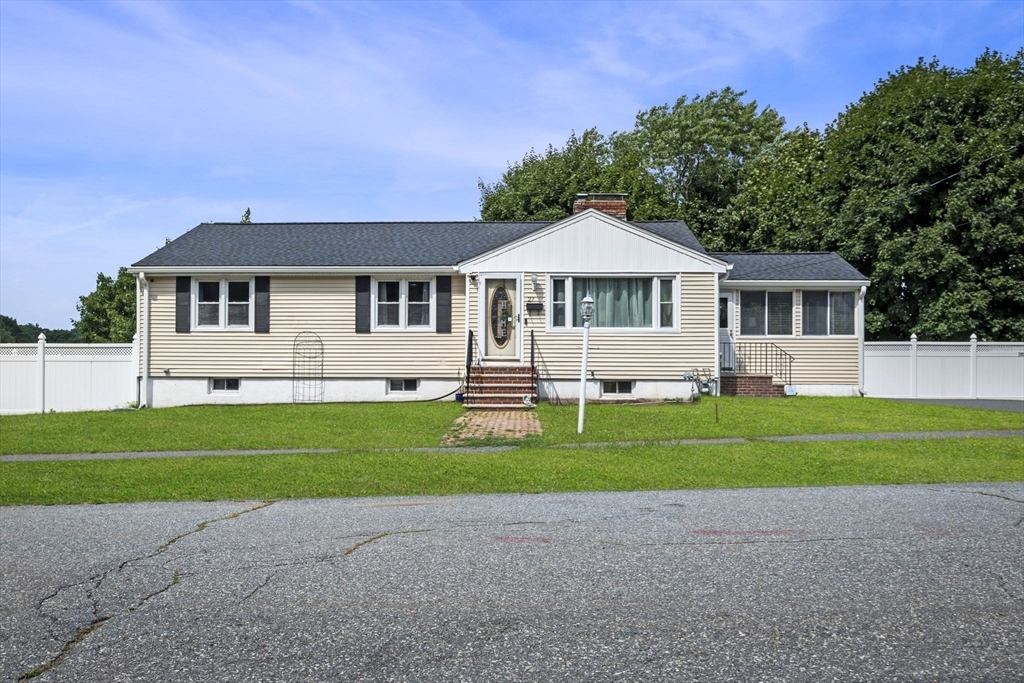 a front view of a house with a garden and trees