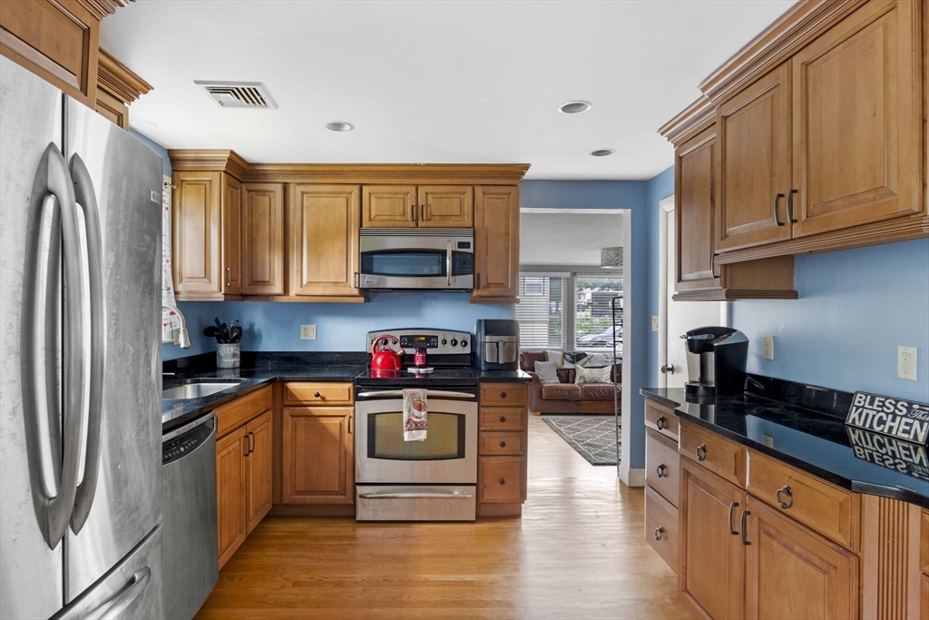 27 Raylen Avenue Peabody, MA 01960 - Photo 12 of 42 a kitchen with stainless steel appliances granite countertop a stove top oven a sink dishwasher and a refrigerator with wooden cabinets