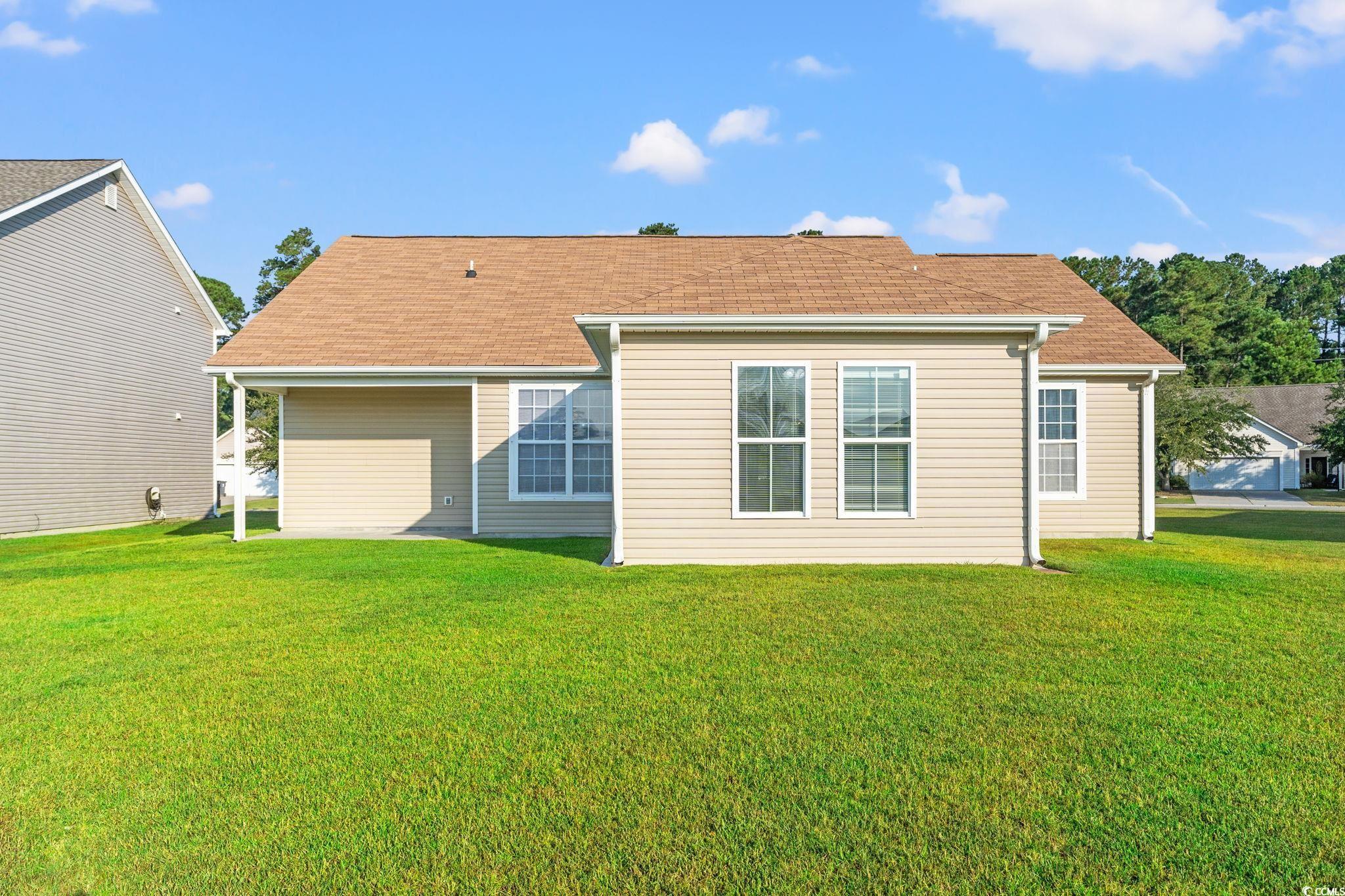 875 Brookline Drive Myrtle Beach, SC 29579 - Photo 28 of 40 Rear view of property featuring a lawn and a shingled roof