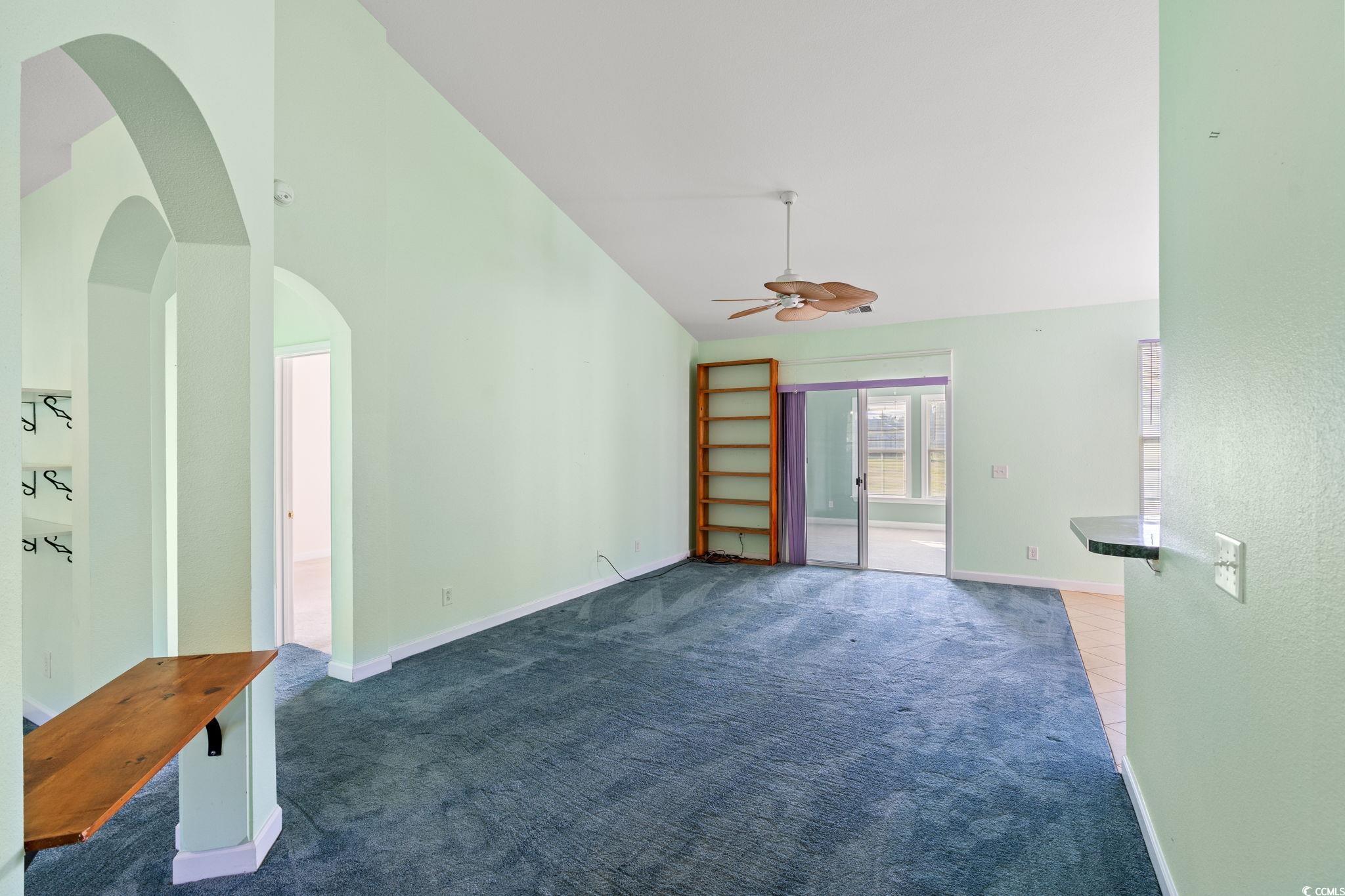 875 Brookline Drive Myrtle Beach, SC 29579 - Photo 6 of 40 Unfurnished living room featuring carpet floors, a ceiling fan, arched walkways, and high vaulted ceiling